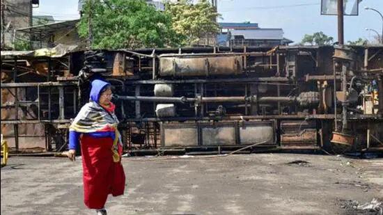 A-woman-walks-past-chassis-of-a-bus-amid-tense-sit_1780312333712